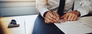 man signing life insurance agreement