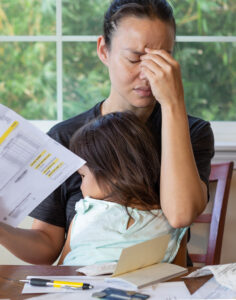 Stressed parent managing finances - term-life insurance offers protection | Weinstein Wealth